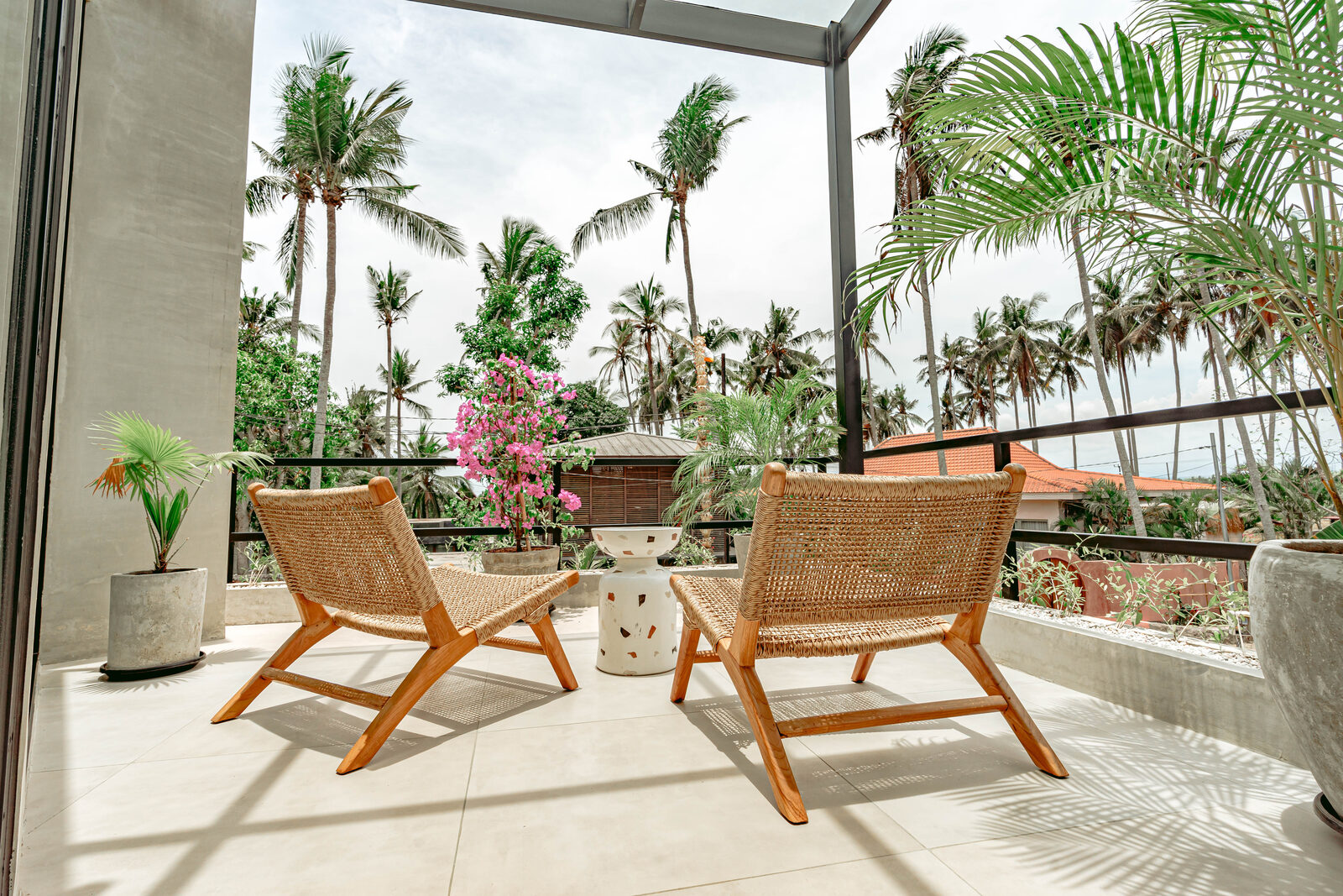 Villa terrace with rattan chairs and palm trees