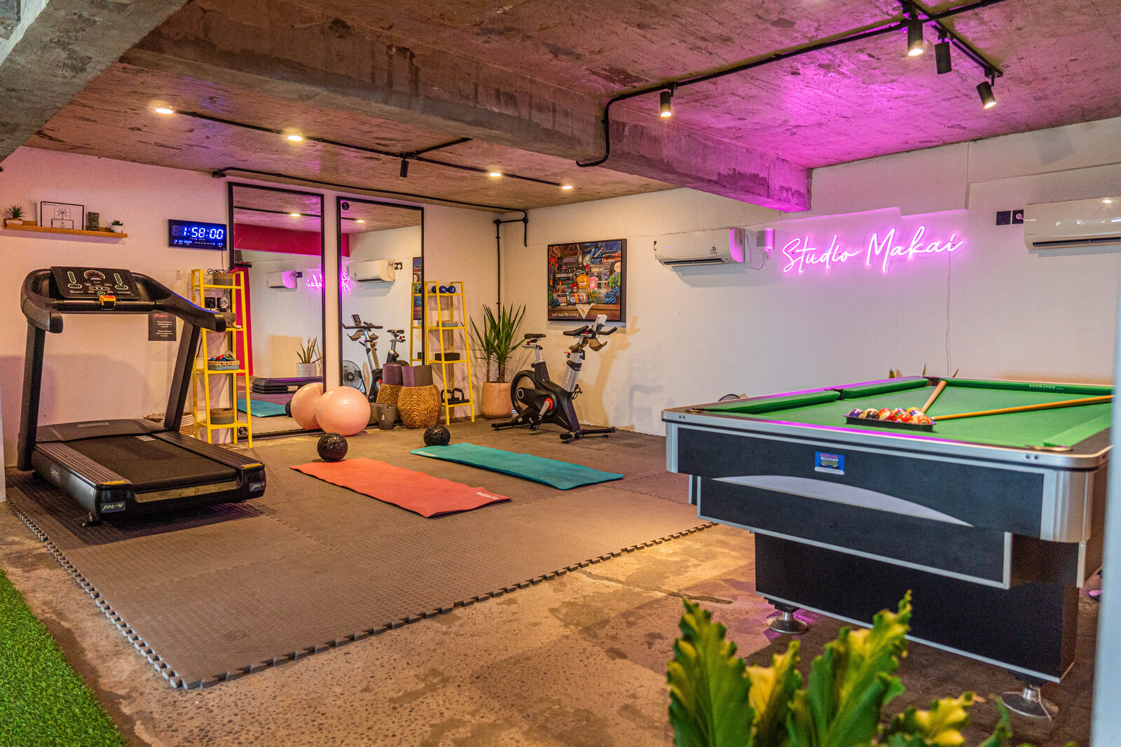 Studio Makai gym with pool table, treadmill and neon signage